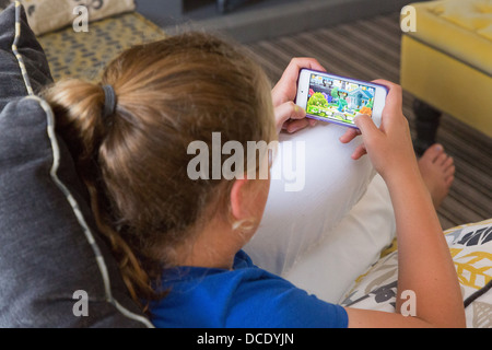 junges Mädchen spielen auf ihrem smartphone Stockfoto
