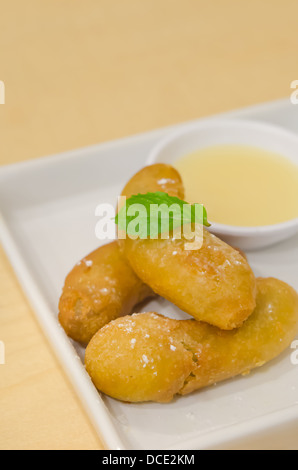 gebackene Banane mit Vanila Sauce auf weißen Teller hautnah Stockfoto