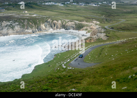 Atlantic Drive Auto auf malerische Küstenstraße mit Strand und dramatische rauer See in der Nähe von Dooega Achill Island County Mayo, Irland Stockfoto