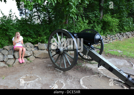 Blonde Teenager-Mädchen Senden von Textnachrichten vom Mobiltelefon weiter, um Kanone auf Schlachtfeld, Gettysburg, Pennsylvania, USA Stockfoto