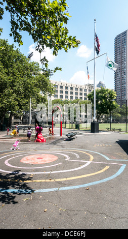 Flaggen wehen über DeWitt Clinton Park mit Baseball Felder Kinder spielen im Wasser-Funktion & bunte Kreide Labyrinth Hells Kitchen Stockfoto