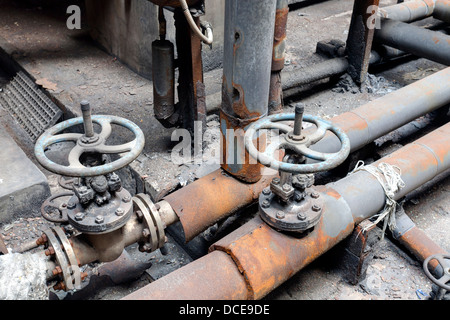 Rohre und Ventile in einer verlassenen Fabrik Stockfoto