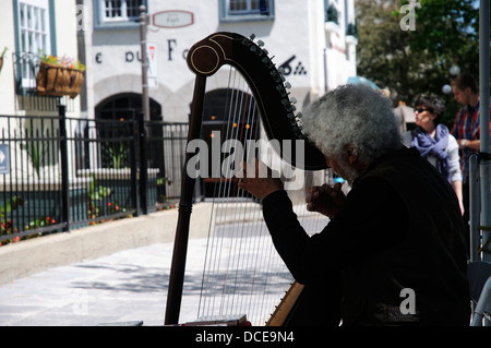 Eine Harfenistin spielt in den Straßen von Quebec Stadt, Quebec, Kanada Stockfoto