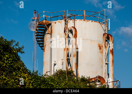 USA, Louisiana, Atchafalaya Basin, rosten Öltank im Bayou Sorrell Shell Oil Field, Satellitenschüssel am Funkturm hinter. Stockfoto