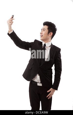 Business-Mann mit Handy-Selbstauslöser Stockfoto