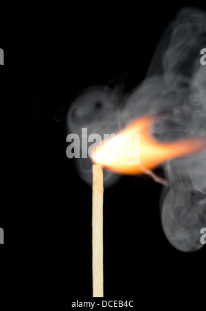 Zündung eines Spiels mit Rauch auf dunklem Hintergrund Stockfoto