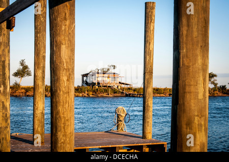 USA, Louisiana, Atchafalaya Basin, Terrabonne Gemeinde, Cocodrie, Dock und kleines Haus in Bayou Petit Caillou, bei Sonnenuntergang. Stockfoto