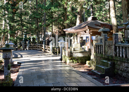 Naka no Hashi Holzbrücke, (mittlere Brücke), unter den Zedern auf dem gepflasterten Fußweg durch den japanischen alten Okunoin Friedhof bei Koya. Stockfoto