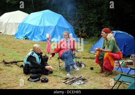 Balcombe Sussex UK 16. August 2013 - sammeln ein Polizei Liason Officer Chats mit Demonstranten neben einem Feuer als anti-Fracking-Aktivisten am Standort Cuadrilla in West Sussex Dorf der Balcombe wo die Firma Explorationsbohrungen durchführen. Tausende von Demonstranten werden voraussichtlich den Protest über das bevorstehende Wochenende beitreten Stockfoto