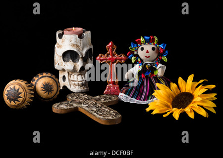 Traditionellen Tag der Toten (Dia de Los Muertos) mexikanischer Altar mit Totenkopf Kerze, Kreuz, Maracas, Sonnenblumen und mexikanische Puppe. Stockfoto