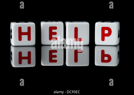 Hilfe buchstabiert im Spiel Würfel Briefe mit Reflexion. Auf schwarzem Hintergrund isoliert. Stockfoto
