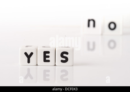 Ja geschrieben in Würfel Buchstaben im Vordergrund mit dem Wort nicht unscharf im Hintergrund. Isoliert auf weißem Hintergrund. Stockfoto