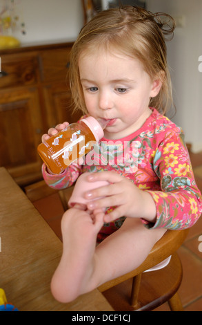 Kleines Mädchen trinken Limonade aus einer Flasche Stockfoto