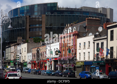 Geschäfte und Kneipen in der Pargate Street, in den Schatten gestellt durch die neuen Criminal Courts of Justice, in der Nähe von the Phoenix Park, Dublin City, Irland Stockfoto