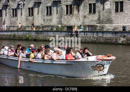 Touristen im Boot auf dem Fluss Leie / Lys während Sightseeing-Trip mit Blick auf die Groot Vleeshuis / große Metzgerei in Gent, Belgien Stockfoto