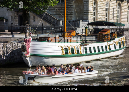 Touristen in Sightseeing-Boot auf dem Fluss Leie / Lys Blick auf dem Kahn, einem historischen Pferdekutsche Boot in Gent, Belgien Stockfoto