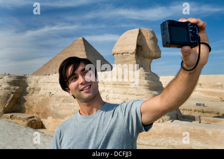 Mann, der ein Bild von sich mit Sphinx im Hintergrund Stockfoto