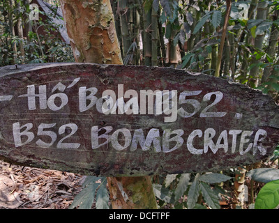 Ein Schild ein Bombentrichter gemacht durch ein USAF b-52 Bomber während des Vietnam-Krieges. Cu Chi Tunnel, Saigon, Vietnam. Stockfoto