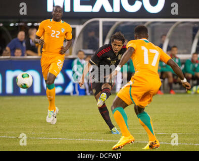 14. August 2013 - East Rutherford, New Jersey, USA - 14. August 2013: Nationalmannschaft Mittelfeldspieler braucht Giovani Dos Santos (10) ein Schuss zwischen zwei Verteidigern der Côte d ' Ivoire Nationalmannschaft während der internationalen freundlich match zwischen Mexiko und Côte d ' Ivoire an Met Life Stadium, East Rutherford, NJ. Stockfoto