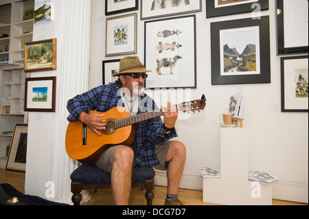 Lokalen Blues-Sänger-Gitarrist Mr H spielt und leeren Ort in The Ardent Gallery Brecon Jazz Festival 2013 Stockfoto