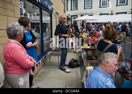 Nik Turner Gründungsmitglied von Hawkwind als Straßenmusikant unter Schar von BesucherInnen auf der Straße während der Brecon Jazz Festival 2013 Stockfoto