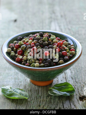 sortierte roten, schwarzen und grünen Pfeffer in einer Schüssel auf dem Tisch Stockfoto