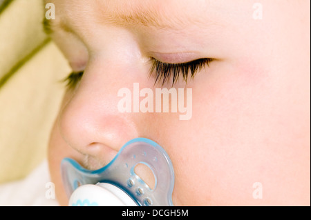 Baby Junge schläft und Schnuller saugen Stockfoto