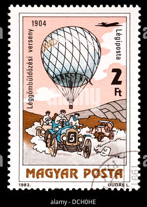 Briefmarke aus Ungarn mit einem Heißluftballon und einem frühen Rennwagen. Stockfoto