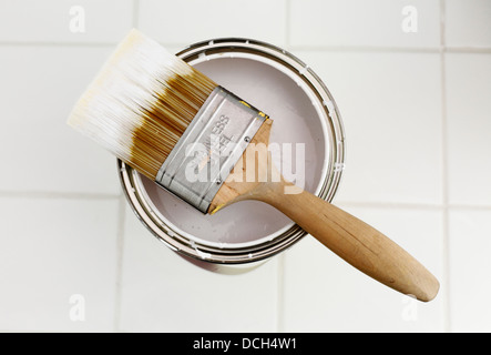 Pinsel und eine offene Dose mit weißer Farbe. Stockfoto