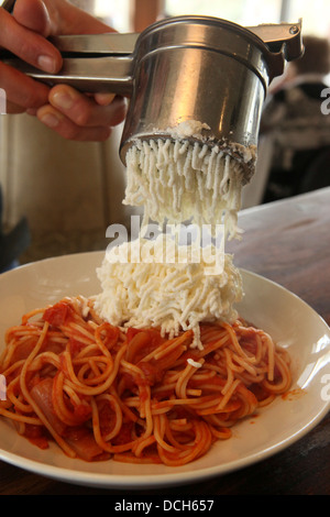 Zubereitung von Spaghetti und marinara Soße hinzufügen den Parmesan-Käse Stockfoto