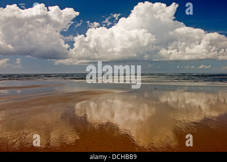 Abstrakte Bilder von Wolken reflektiert im nassen Sand. Stockfoto