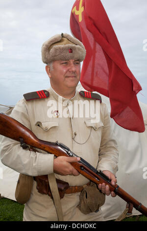 Russische Soldaten, Militärreenaktor in Lytham, Blackpool. 18.. August 2013. Paul Fricker (MR) aus Northallerton trägt Shapka-ushanka, einen Re-enactor mit einem Mosin-Nagant Modell 1891/30 Gewehr und trägt das Kostüm eines russischen Soldaten auf dem Lytham 1940er Kriegsfestival in Lytham Green, Lancashire, Großbritannien. Stockfoto