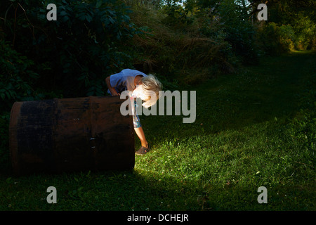 Kind junge finden Sie einen Schatz in magische Fass in der Abenddämmerung Stockfoto