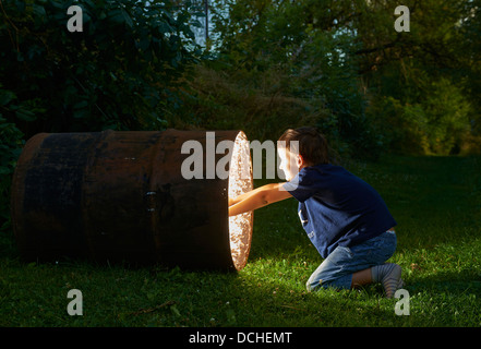 Kind junge finden Sie einen Schatz in magische Fass in der Abenddämmerung Stockfoto