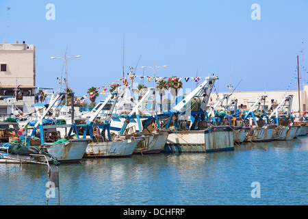 Italienische Angelboote/Fischerboote vertäut im Hafen von Mola di Bari in Apulien, Süditalien unter einem strahlend blauen Himmel Stockfoto