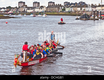 Drachen Boot Team in Richtung Startpunkt Rennen auf dem Fluss Irvine im Rahmen des Marymass Festivals Irvines Rudern. North Ayrshire Stockfoto