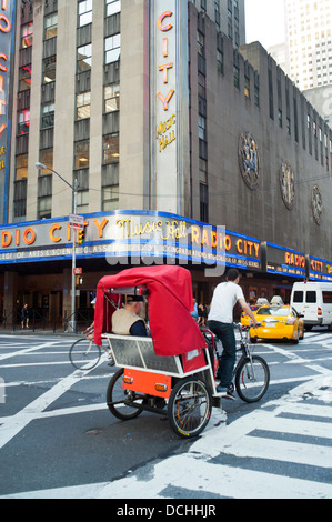 Eine Fahrradrikscha auf der Straße vor der Radio City Music Hall in New York City. Stockfoto