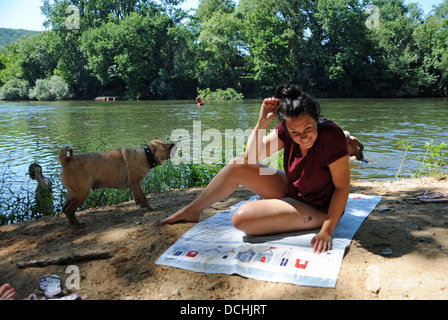 Junge Frau beim Sonnenbaden Fluss Lot mit Hund Wasser abschütteln, in der viele Region oder Abteilung der Süd-West-Frankreich Stockfoto