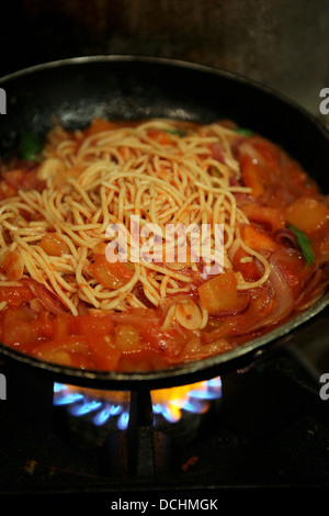 Zubereitung von Spaghetti und marinara Soße Sauce der Spaghetti hinzufügen Stockfoto