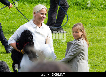 Oslo, Norwegen. 18. August 2013. Kronprinzessin Mette-Marit von Norwegen (L), mit einem der Welpen von königlichen Hund Milly Kakao und Prinzessin Ingrid Alexandra kommt mit einem der Welpen von königlichen Hund Milly Kakao für ein Outdoor-Gottesdienst im Park um den Königspalast in Oslo, Norwegen, 18. August 2013. Der Dienst wurde im Rahmen der Feier des 40. Geburtstag Kronprinzessin Mette-Marit inszeniert. Foto: Albert Nieboer //dpa/Alamy Live-Nachrichten Stockfoto