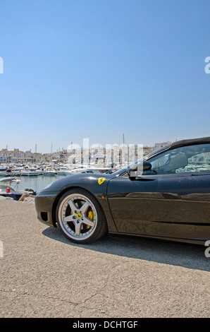 Ferrari parkte vor dem weißem Portwein-Dorf in Puerto Banus, Marbella, Spanien. Stockfoto