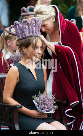 Amelinghausen, Deutschland. 18. August 2013. 19-Year-Old Lara-Sophie Sebastian erhält die Krone von ihrer Vorgängerin Jana George nach ihrer Wahl als die neue Heather Queen in Amelinghausen, Deutschland, 18. August 2013. Die Wahl ist der Höhepunkt des jährlichen "Heidebluetenfest" (lit.) "Heather Blumenfest"). Nach der Krönung beginnt der traditionelle Umzug mit geschmückten Wagen Festival, Musikgruppen und Predestrians. Foto: PHILIPP SCHULZE/Dpa/Alamy Live News Stockfoto