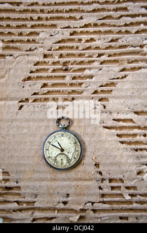 alten Grunge-Taschenuhr auf Karton Hintergrund Stockfoto