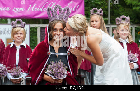 Amelinghausen, Deutschland. 18. August 2013. 19-Year-Old Lara-Sophie Sebastian bekommt einen Kuss von ihrem Vorgänger Jana George nach ihrer Wahl als die neue Heather Queen in Amelinghausen, Deutschland, 18. August 2013. Die Wahl ist der Höhepunkt des jährlichen "Heidebluetenfest" (lit.) "Heather Blumenfest"). Nach der Krönung beginnt der traditionelle Umzug mit geschmückten Wagen Festival, Musikgruppen und Predestrians. Foto: PHILIPP SCHULZE/Dpa/Alamy Live News Stockfoto