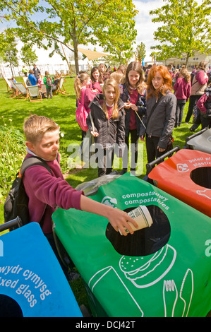 Schulkinder in der Hay Festival setzen Abfallbehälter an einem Lagerplatz für das recycling. Stockfoto