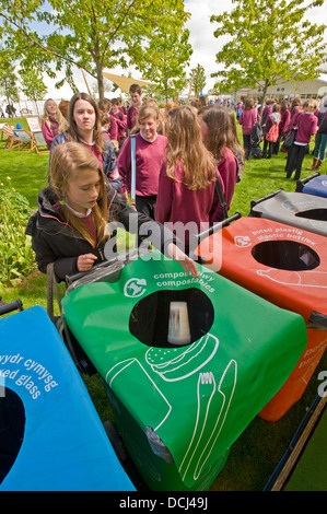Schulkinder in der Hay Festival setzen Abfallbehälter an einem Lagerplatz für das recycling. Stockfoto