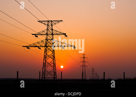 Sonnenuntergang unter dem Hochspannungs-Turm im Hintergrund Stockfoto