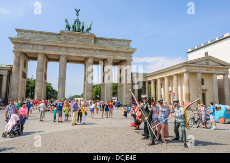 2 junge Frauen mit Visor Caps und 2 Soldaten mit amerikanischer und deutscher Flagge posiert vor dem Brandenburger Tor - Brandenburger Tor - Berlin-Deutschland Stockfoto