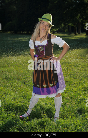 junge Frau trägt traditionelle bayerische Dirndl Kleid, in einem park Stockfoto
