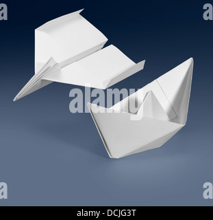 weißes Papier Schiff und Papier Flugzeug in blauen Gradienten Rücken Stockfoto